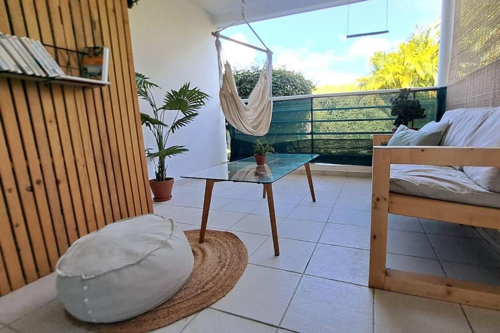 a room with a table and a hammock on a balcony at Coeur de Rhoda in Saint-François