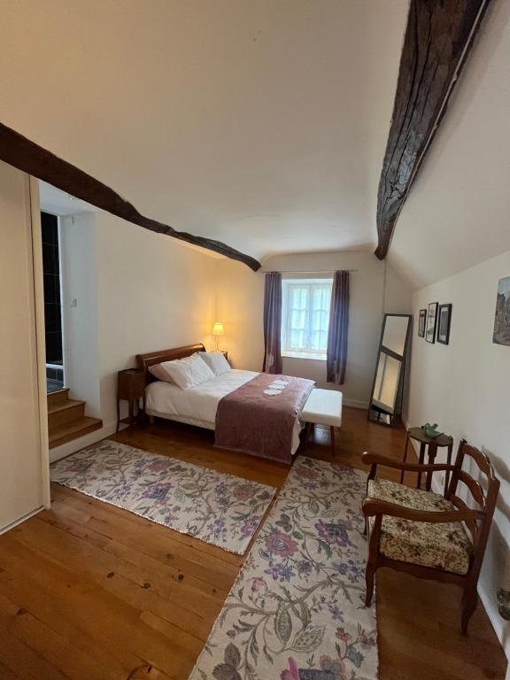 une chambre avec un lit, une table et une chaise dans l'établissement La Maison dans le jardin du Manoir de Bouron, à Moigny