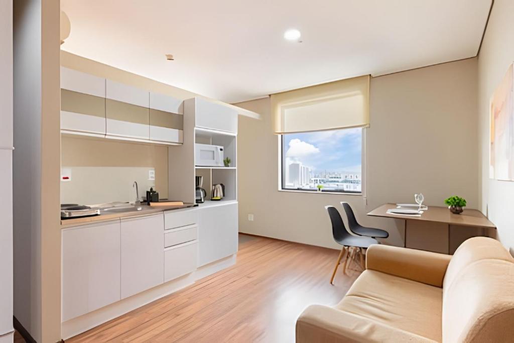 a kitchen and living room with a couch and a table at Flats Osasco Trade Center in Osasco