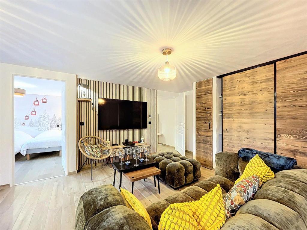 a living room with a couch and a tv at Appartement rénové, ski aux pieds, centre station, 8 pers, balcon, WiFi - FR-1-267-301 in La Toussuire