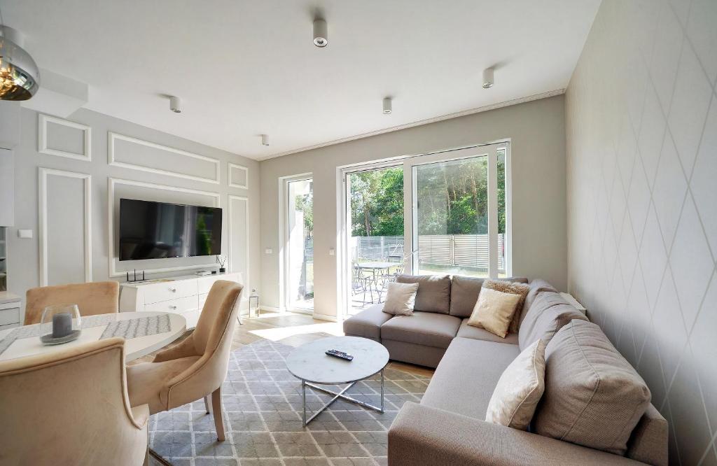 a living room with a couch and a table at Apartament Glamour in Pobierowo