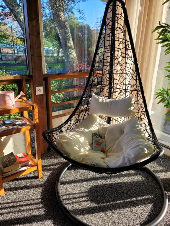 a hanging hammock chair in a room with a window at Chalet familial entre lac et fôret in Azur