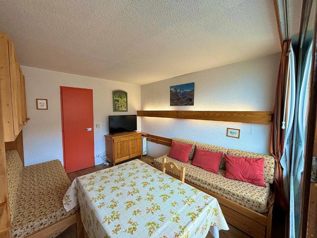 - une chambre avec un lit, un canapé et une porte rouge dans l'établissement Studio au pied des pistes, animaux admis, 2 pers - FR-1-452-53, aux Menuires