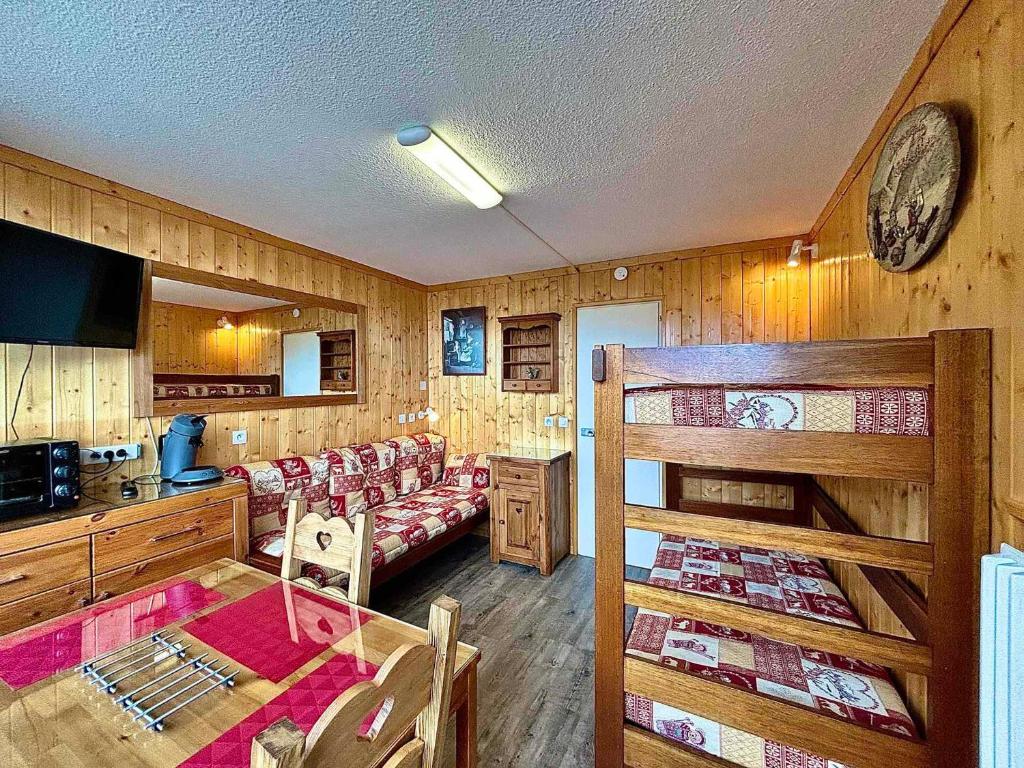 Cette chambre comprend des lits superposés, une table et des chaises. dans l'établissement Charmant Studio au Cœur des Menuires, Proche Pistes et Commerces - FR-1-452-127, aux Menuires