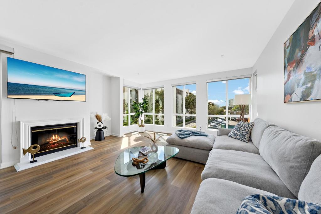 een woonkamer met een bank en een open haard bij The Turquoise Lounge - Chic 2BR Beach view Pool, Sauna in Los Angeles