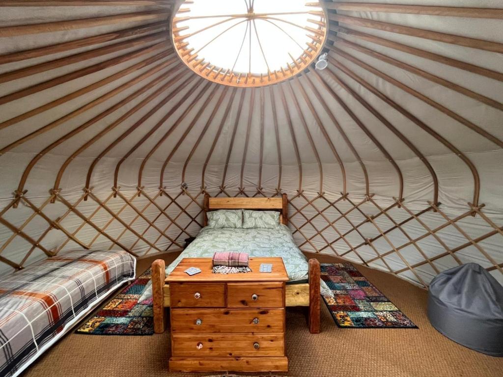 a room with a bed and a table in a yurt at Yurt in Hayle