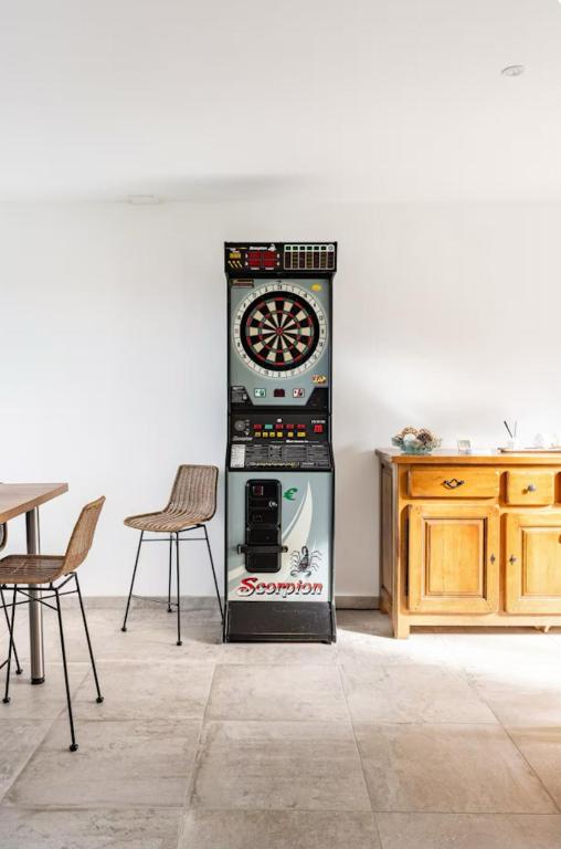 - une machine munie d'une horloge dans une pièce dans l'établissement Maison plain-pied 4 chambres Graye sur mer plage à 700 m, à Graye-sur-Mer