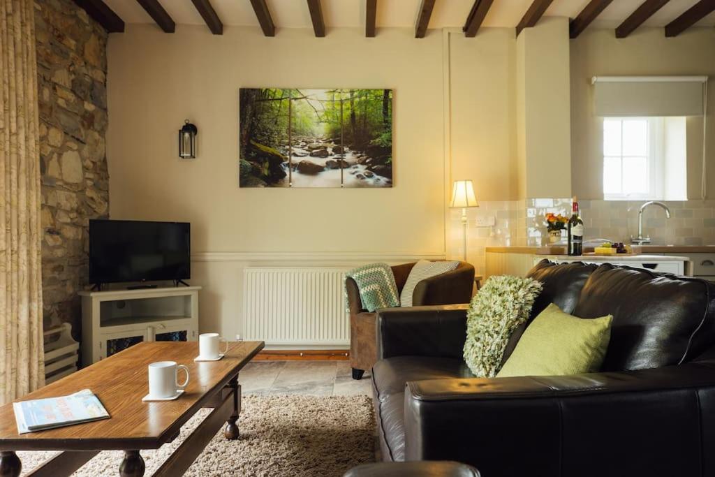a living room with a couch and a table at Coach House Cottage at Scolton - Indoor pool in HAW