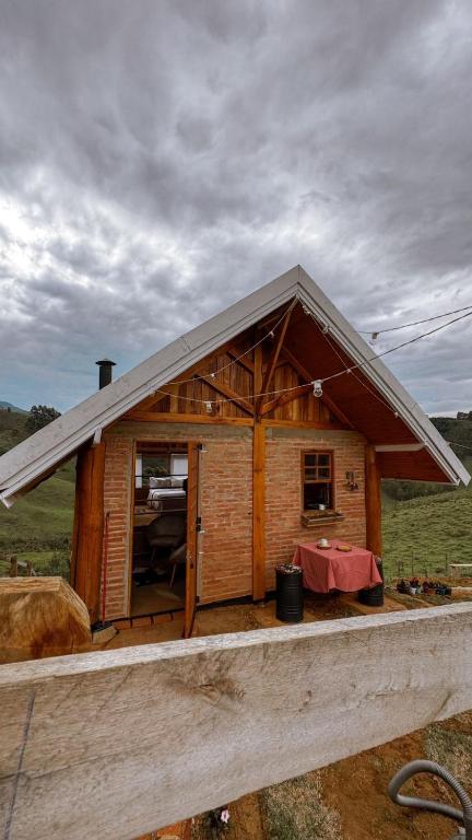 a small wooden house with a pitched roof at Vilare's da Mantiqueira in Queimada