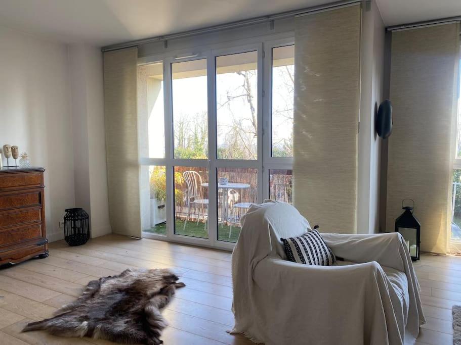 un chien assis sur une chaise dans un salon dans l'établissement Au Milieu des Arbres, à Suresnes