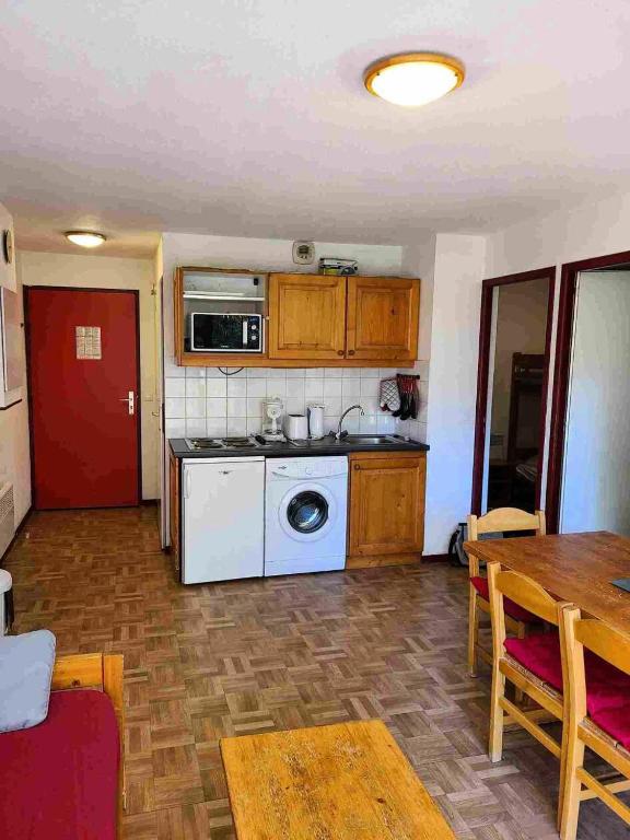 un salon avec une cuisine et une table dans l'établissement Résidence Le Cheval Blanc - 2 Pièces pour 6 Personnes 193182, à Modane