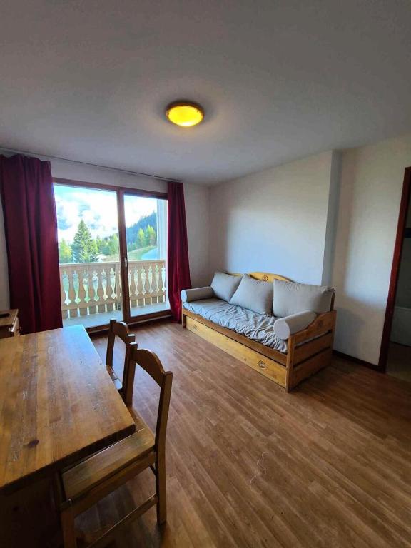 un salon avec un canapé et une table dans l'établissement Résidence Le Cheval Blanc - Studio pour 4 Personnes 193124, à Modane