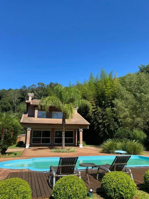 een huis met een zwembad en twee stoelen en een tafel bij Sitio Entre Rios in Guaporé