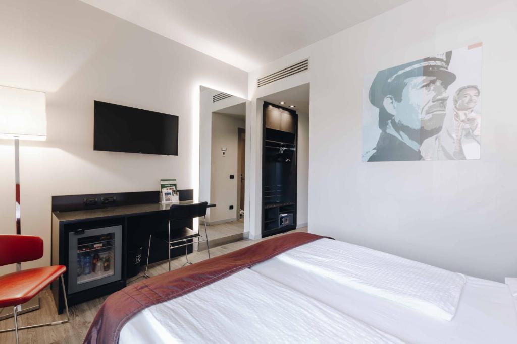 biała sypialnia z łóżkiem i telewizorem w obiekcie Hotel Continental w mieście Cremona