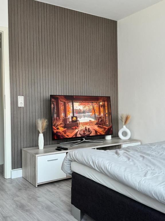 a bedroom with a flat screen tv on a wall at Gemütliches Apartment vor den Toren Kölns in Hürth