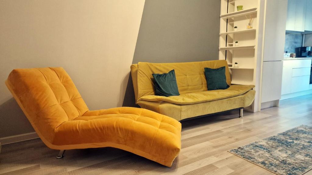 een gele stoel en een bank in de woonkamer bij Sophia Home 2 in Braşov