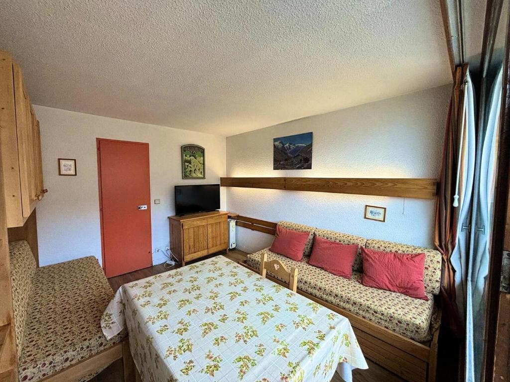 - une chambre avec un lit et un canapé avec des oreillers rouges dans l'établissement Résidence Chaviere - Studio ski aux pieds au coeur des Ménuires MAE-6174, aux Menuires