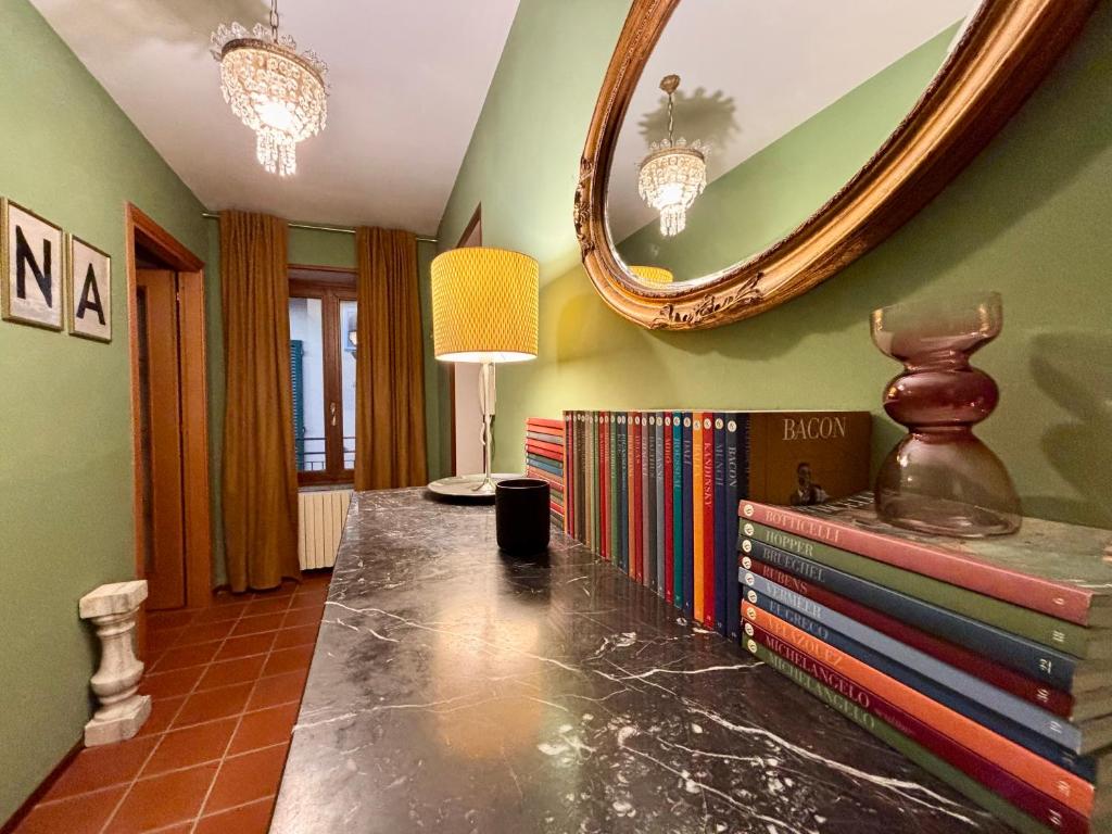 a room with a table with books and a mirror at Oh!megna in Omegna
