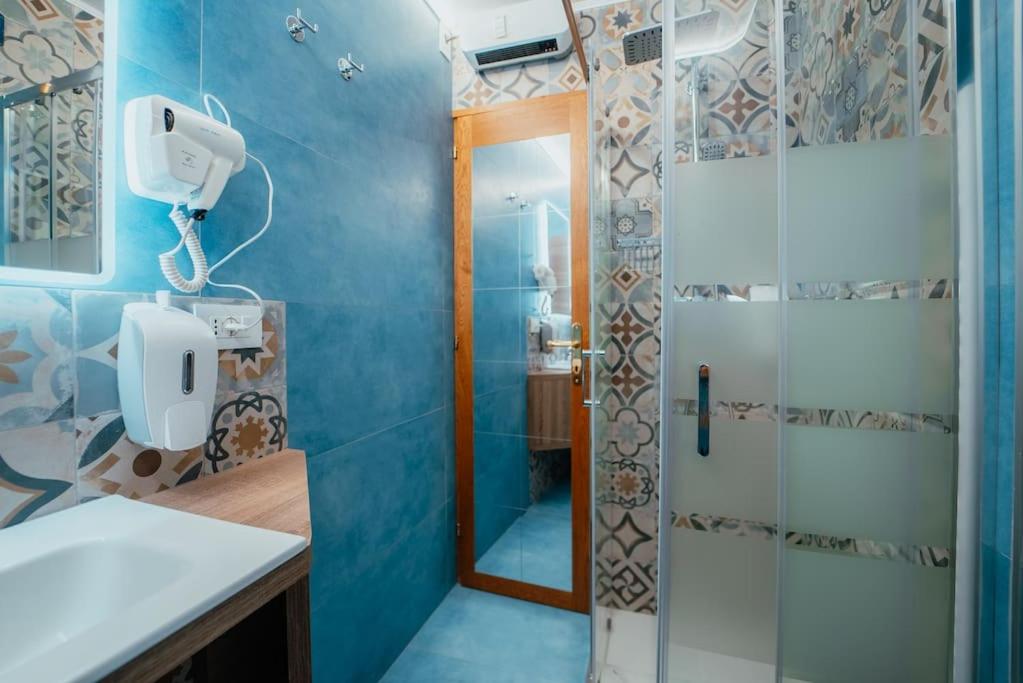 une salle de bain avec douche et porte vitrée dans l'établissement Monolocale La casa delle fate, à Madonna di Campiglio