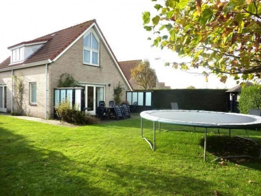Un trampolín en un patio frente a una casa. en Bungalow in Breskens near Beach & Lighthouse, en Breskens