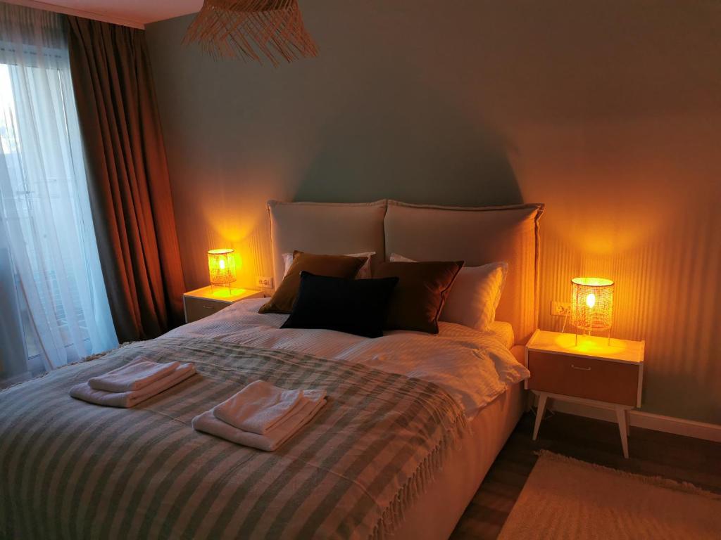 a bedroom with two towels on a bed with two lamps at Flat Colina Magurii Bacau in Măgura
