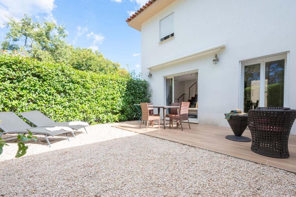 eine Terrasse mit einem Tisch und Stühlen neben einem Haus in der Unterkunft 83zenvilla-2 in Montauroux