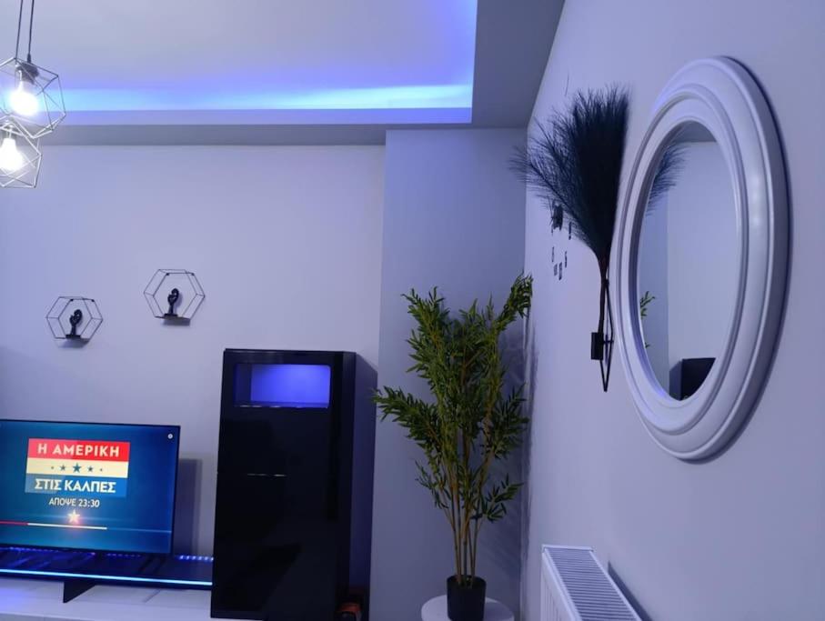 a room with a round mirror and a tv at Vision Apartment "self check in" Thessaloniki in Thessaloniki