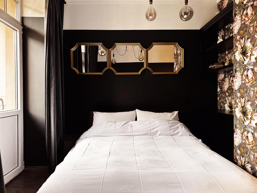 een slaapkamer met een wit bed en een zwarte muur bij Central & Functional Studio Riga in Rīga