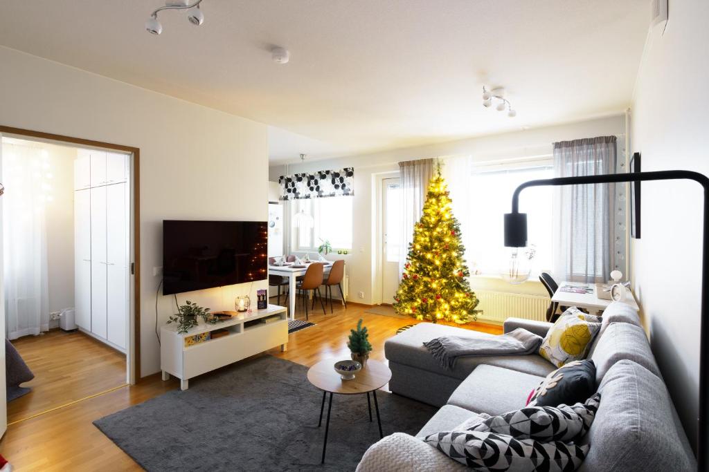 un soggiorno con un albero di Natale e un divano di Adorable Arctic Apartments - Private Sauna & Free Parking a Rovaniemi