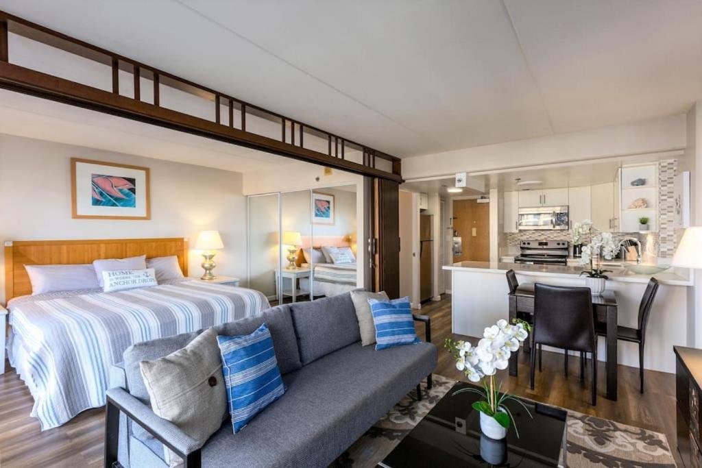 a bedroom with a bed and a living room at 1519 Ilikai Collection 9 Beachfront Resort recently upgraded in Honolulu