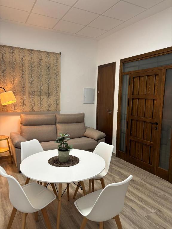 a living room with a table and chairs and a couch at Loft Plaza in Hornachuelos