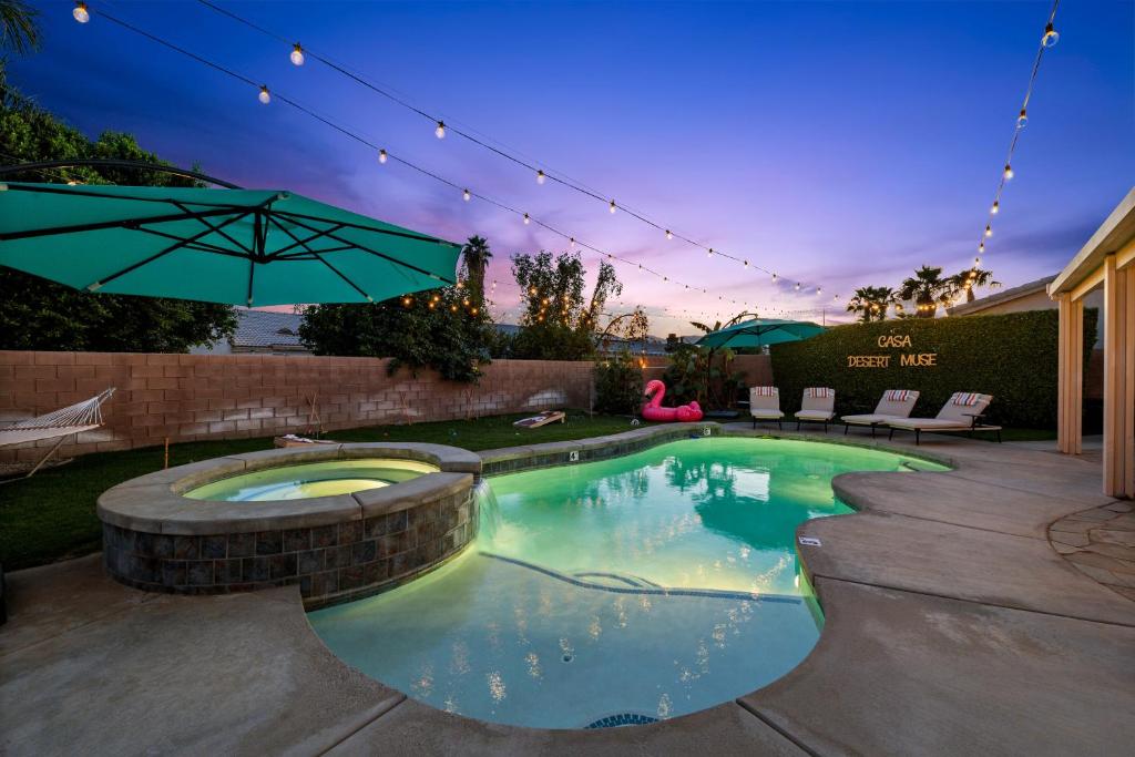 インディオにあるCasa Desert Muse with Heated Pool Spa Firepit Mini Golf and Gamesの裏庭の傘付きスイミングプール