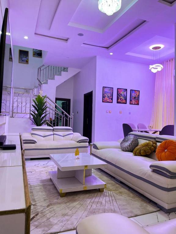 a living room with white couches and a table at 4 bedroom duplex entire space at Chevron lekki Lagos Nigeria in Lekki