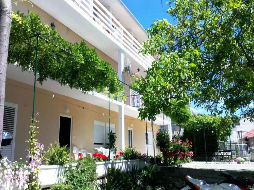 a building with flowers and plants in front of it at Apartments Boro in Dugi Rat