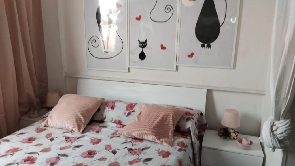 a bedroom with a bed and some pictures on the wall at Mis Flores, spiaggia privata in Santa Marinella