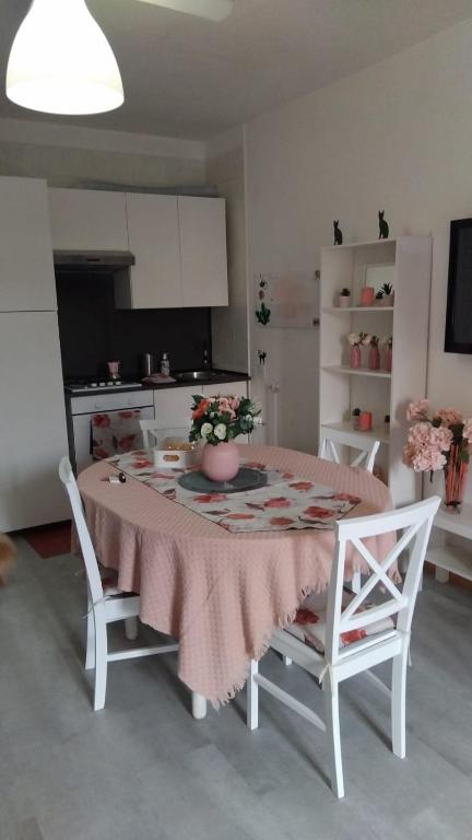 a kitchen with a table with a vase of flowers on it at Mis Flores,appartamento con parcheggio, parco e spiaggia privata in Santa Marinella