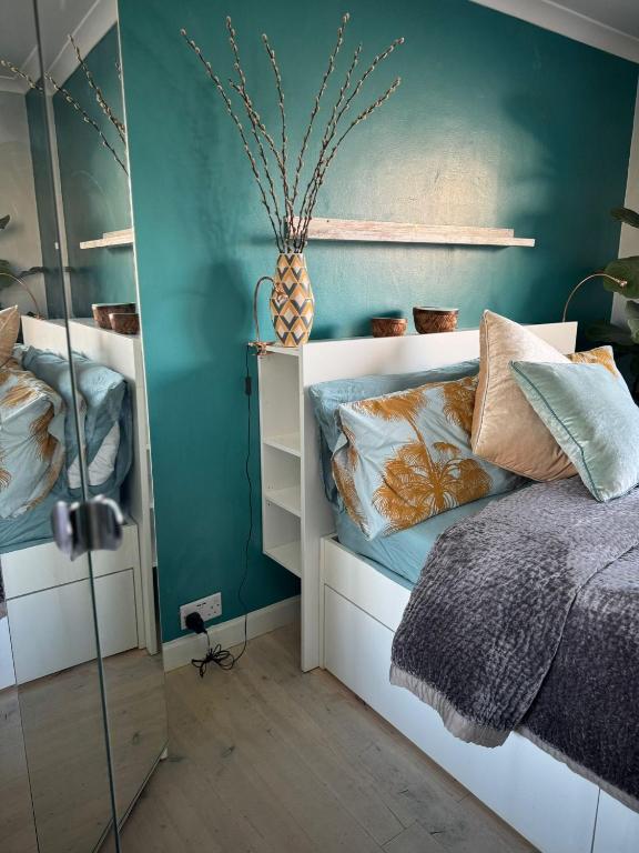 a bedroom with a bed and a green wall at Milan Casa in Winnersh
