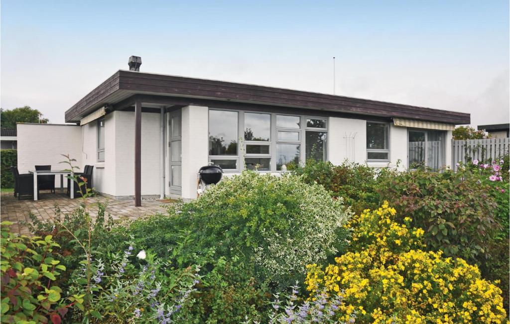 a white house with a garden in front of it at Three-Bedroom Holiday Home In Nyborg in Nyborg