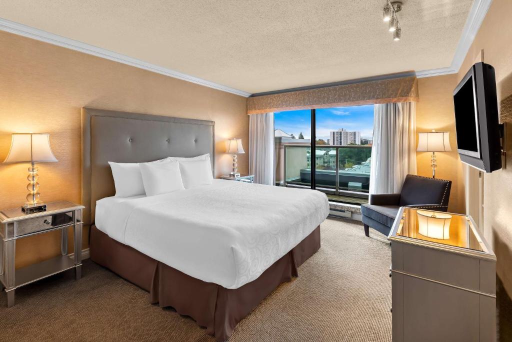 a hotel room with a large bed and a window at Best Western PLUS Inner Harbour Hotel in Victoria