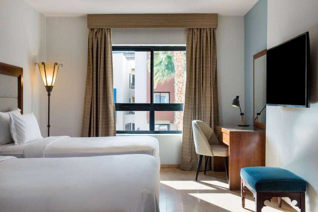 a hotel room with two beds and a window at Marina Resort Port Ghalib, a member of Radisson Individuals in Port Ghalib