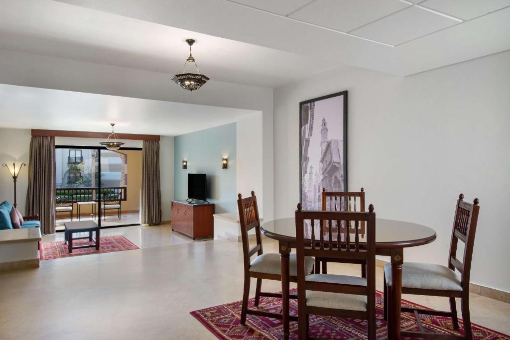 a dining room and living room with a table and chairs at Marina Resort Port Ghalib, a member of Radisson Individuals in Port Ghalib