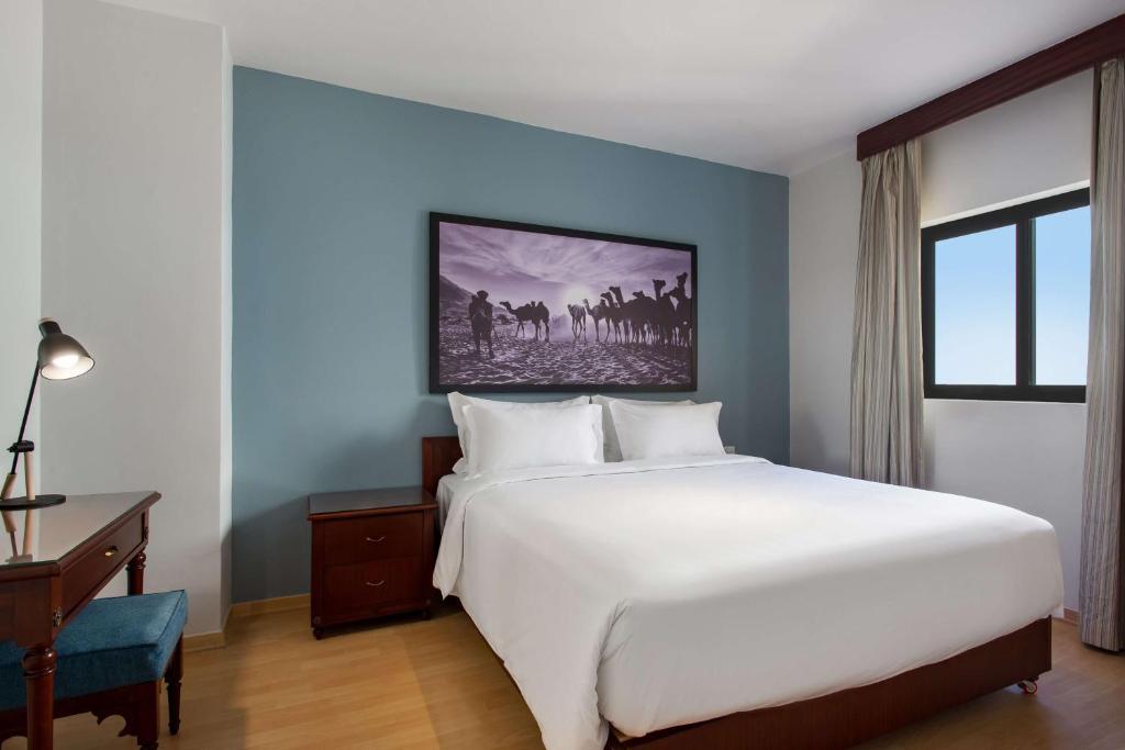 a bedroom with a large white bed and a desk at Marina Resort Port Ghalib, a member of Radisson Individuals in Port Ghalib