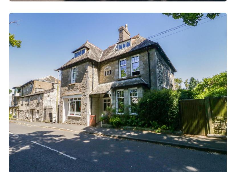 a large stone house on the side of a street at Seaside & Lake District Retreat in Arnside