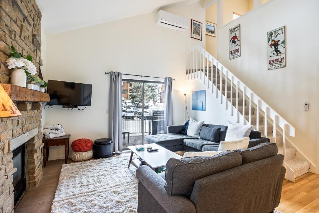 a living room with a couch and a fireplace at Walk to Lift, Sleeps 6, Shared Hot Tub, Cozy Interiors, Gourmet Dining, Fireplace and Patio in Park City