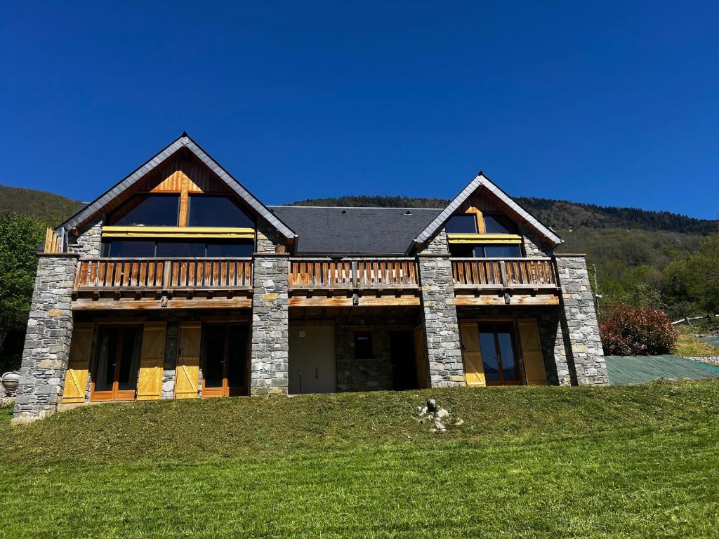 une maison sur une colline avec un chien devant elle dans l'établissement Chalet de luxe contemporain vue 360 degrés sur les montagnes, à Guchan
