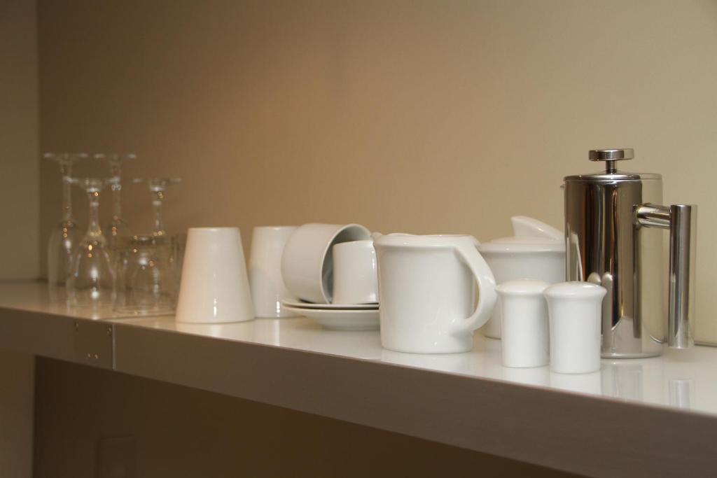 a counter with white cups and utensils on it at Bentleys Motor Inn in Palmerston North