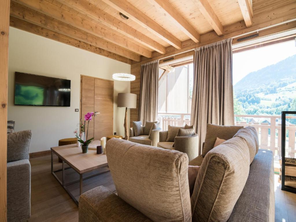 un salon avec un canapé, des chaises et une table dans l'établissement Chalet in Megève with Mont-Blanc Views, à Praz-sur-Arly