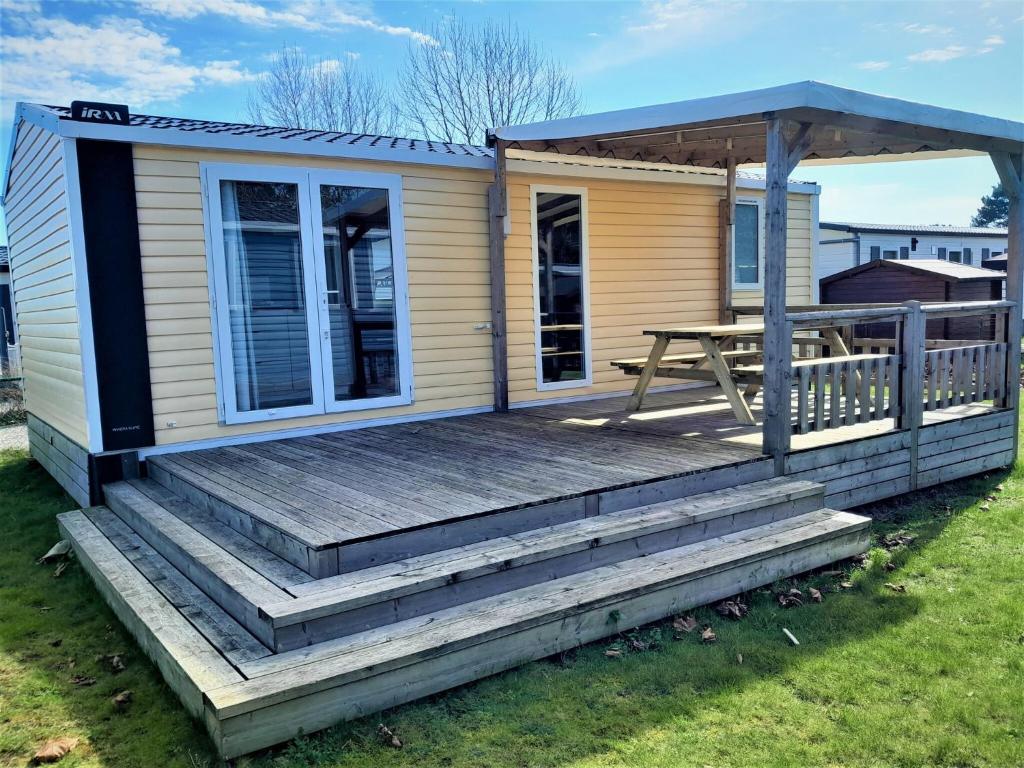 a house with a wooden deck with a picnic table at Charming Breebos Getaway in Rijkevorsel