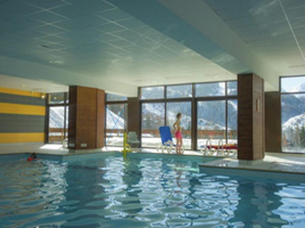 une personne debout dans une piscine d'un bâtiment dans l'établissement Apartment in France with Ski Views, à Valloire