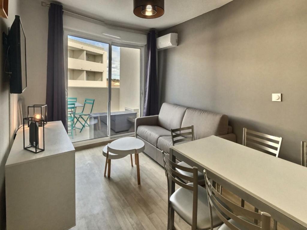 un salon avec un canapé, une table et des chaises dans l'établissement Apartment in Valras-Plage near Sandy Beach, à Sérignan